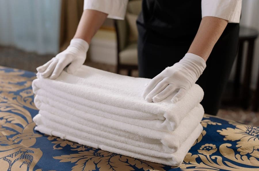 Stack of crisp white hotel bath sheets being folded