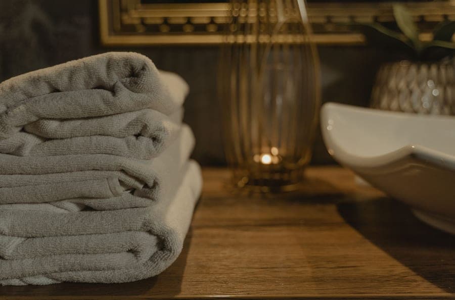 Folded cotton bath sheets stacked on a bathroom counter