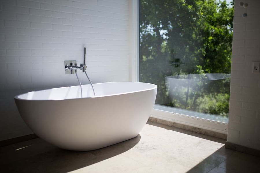Compact cotton tub mat in front of a bathtub