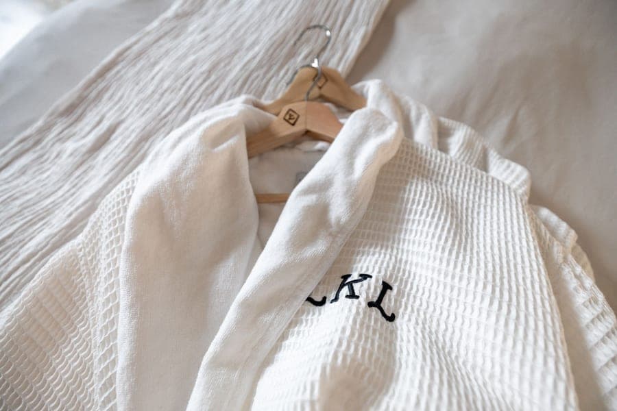Hooded cotton terry bathrobe on a wooden hanger