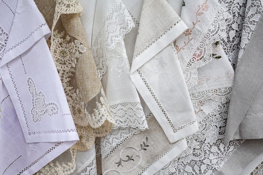 Folded white cotton bath towel with an embroidered border