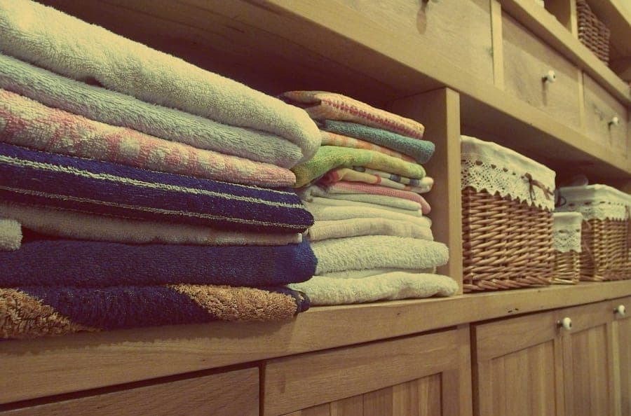 Crisp white hotel-style folded bath towels on a shelf