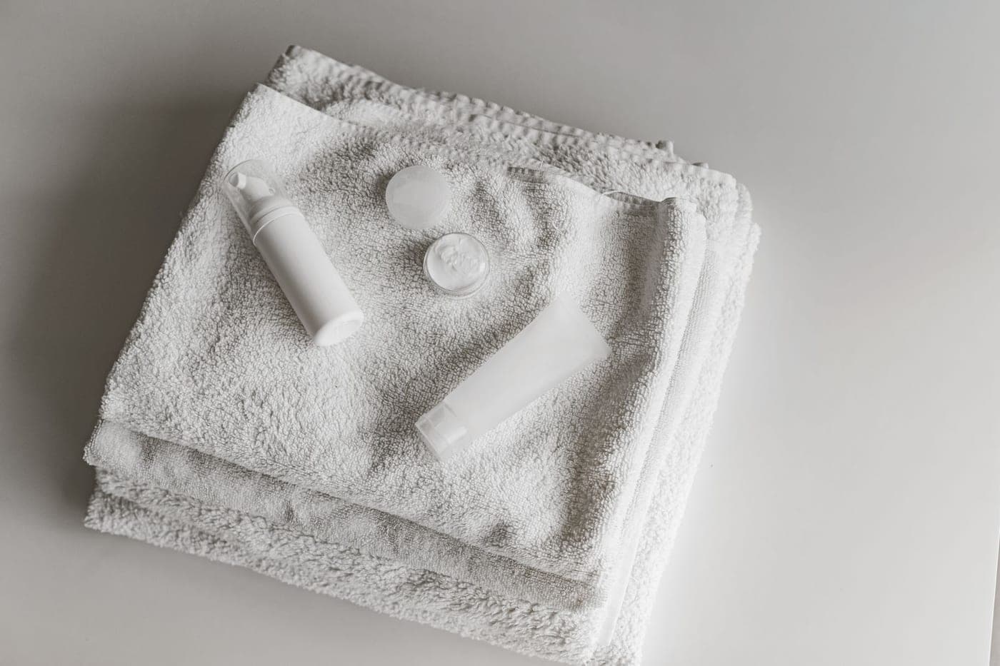 A thick white cotton bath rug on a bathroom floor