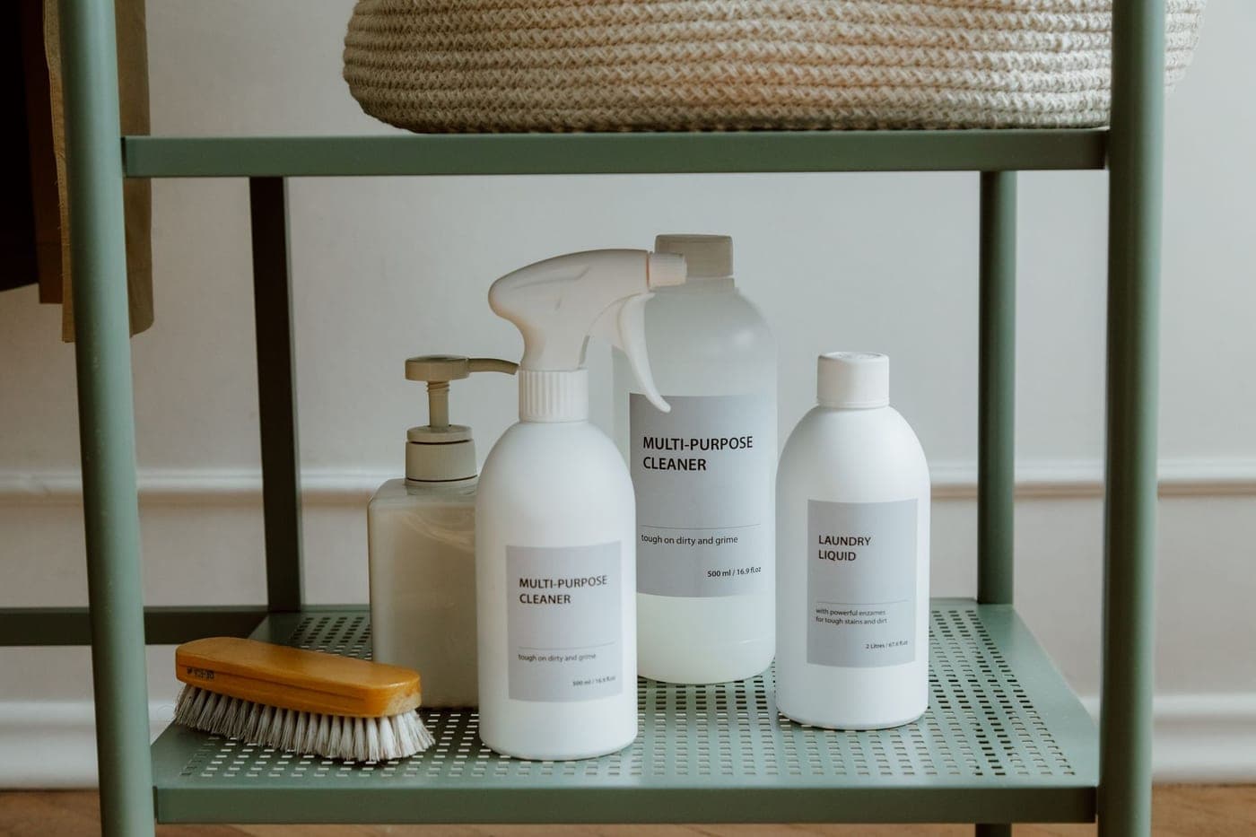 Laundry detergent and boosters beside a stack of clean towels