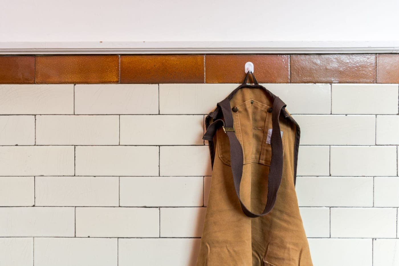 A thick white terry cloth bathrobe on a hanger