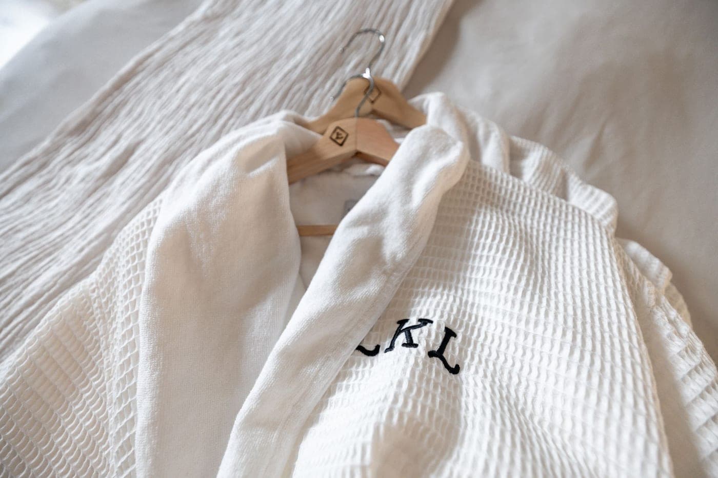 A waffle weave cotton robe folded on a bench