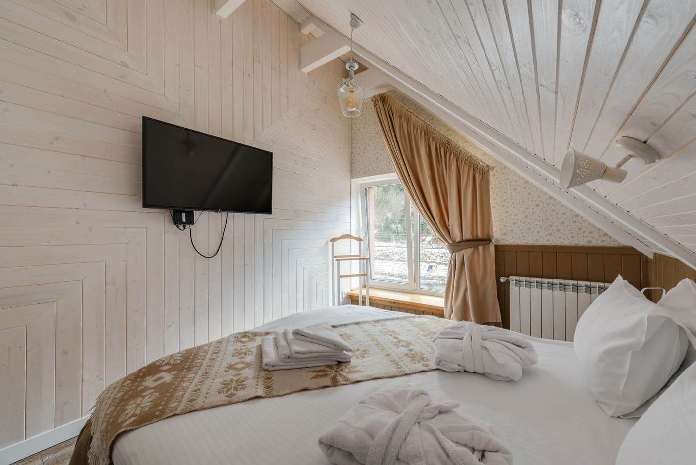 An oversized white resort bath sheet folded on a bench