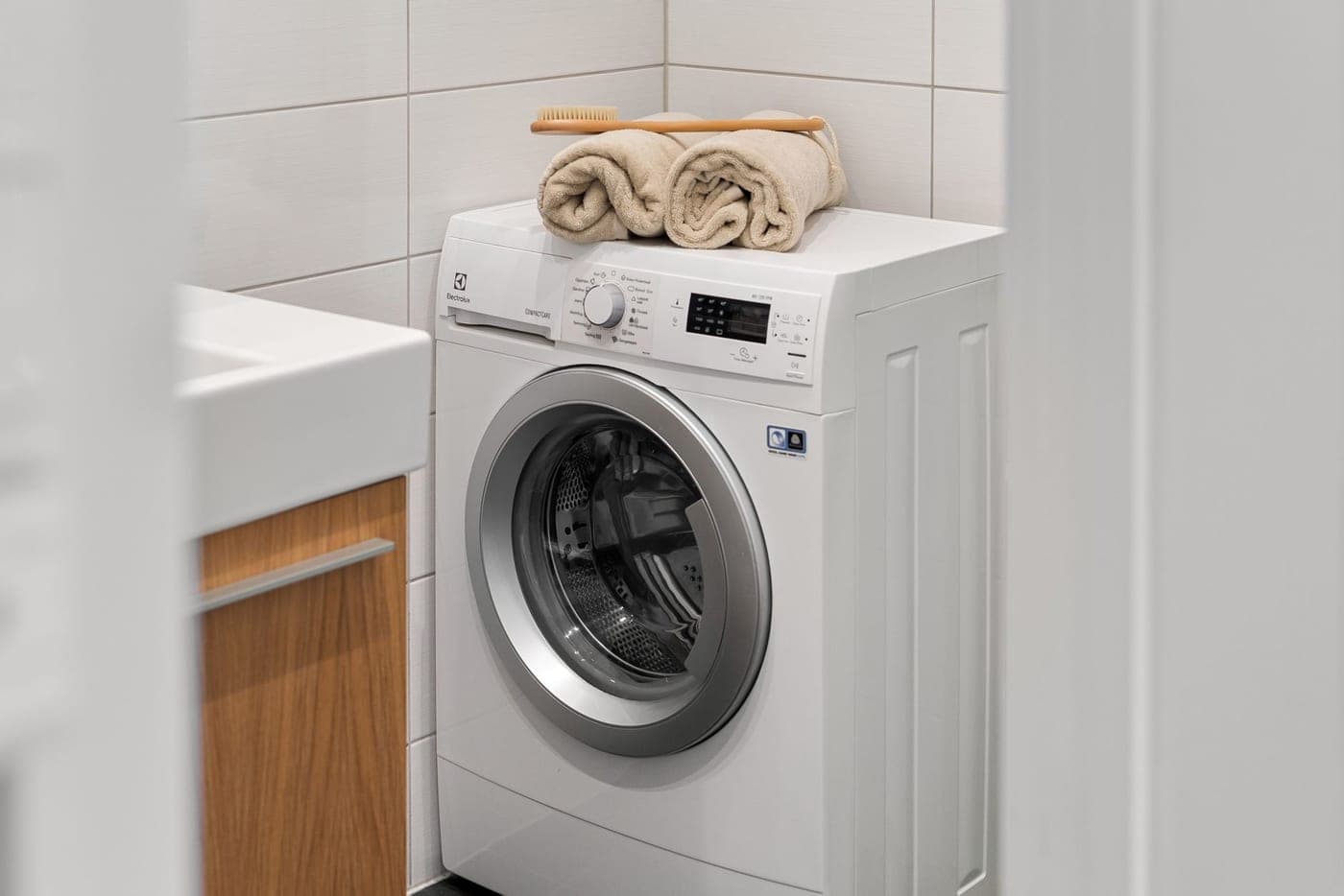 A cotton bathrobe being loaded into a washing machine