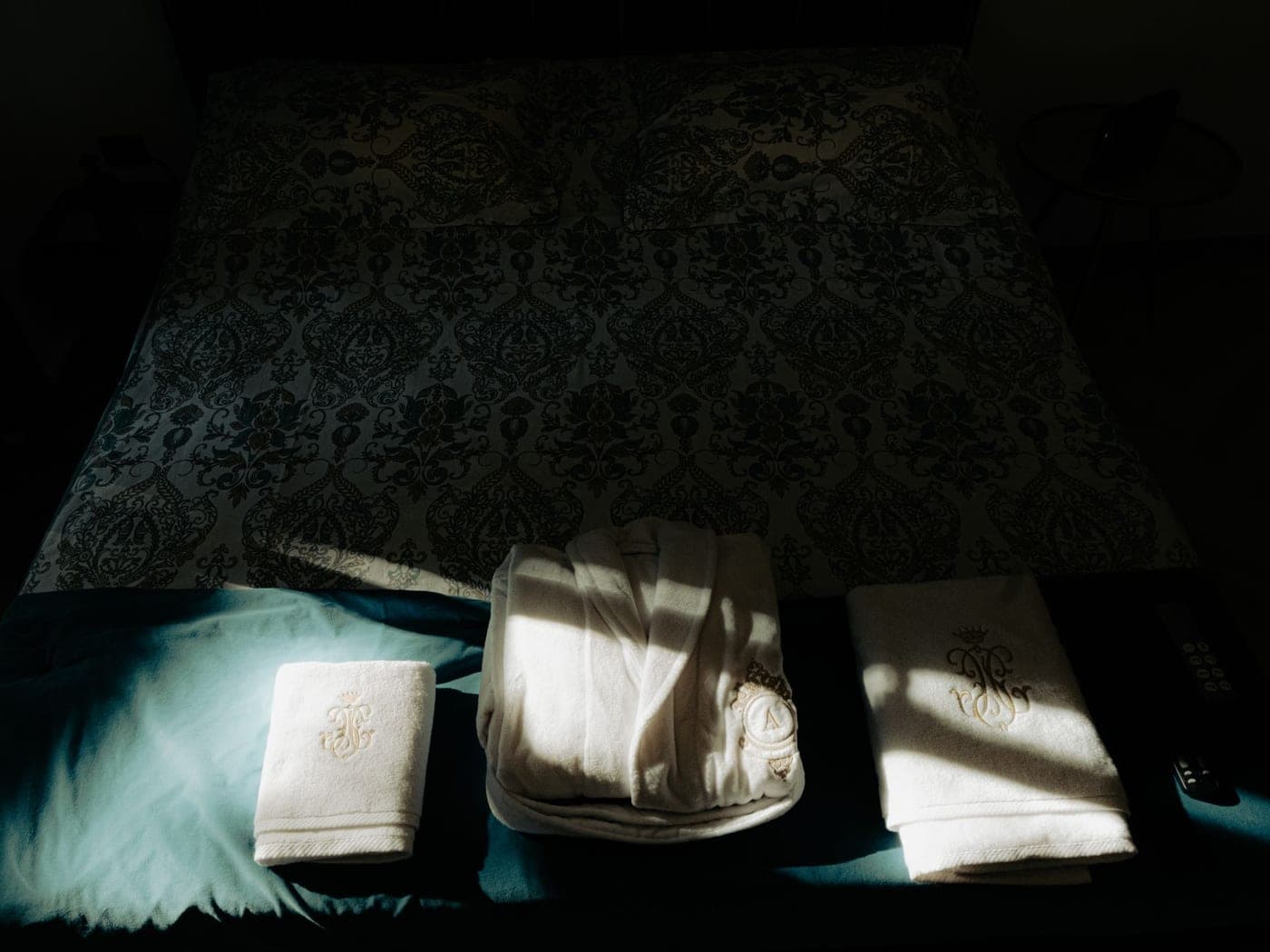 A white cotton bath towel with an embroidered border